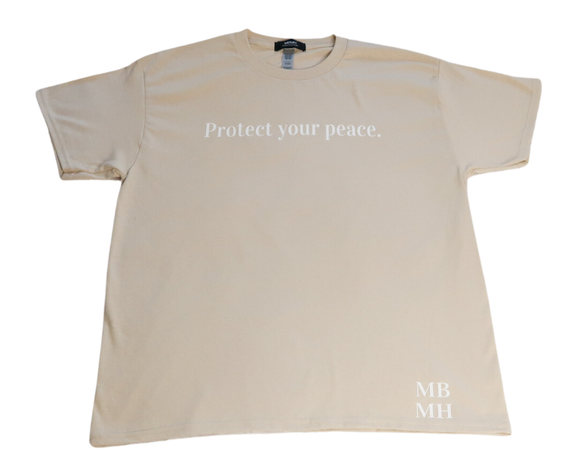 Short sleeve sand colored t-shirt with white vinyl lettering with phrase “Protect your peace.”